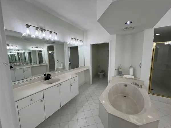 a spacious bathroom with a granite countertop sink and a mirror