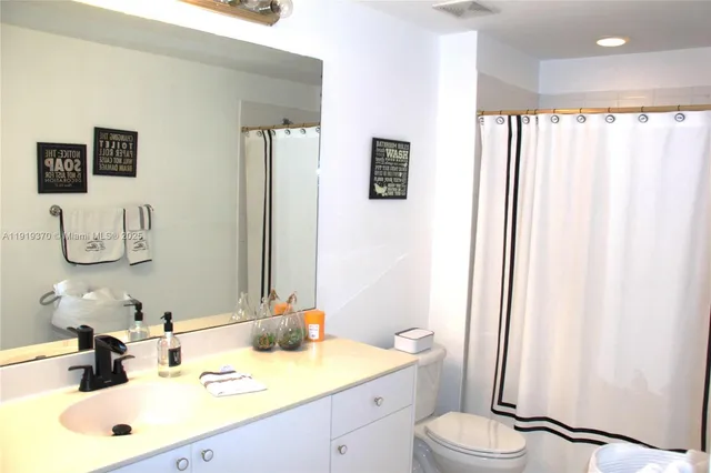 a bathroom with a sink a toilet and mirror