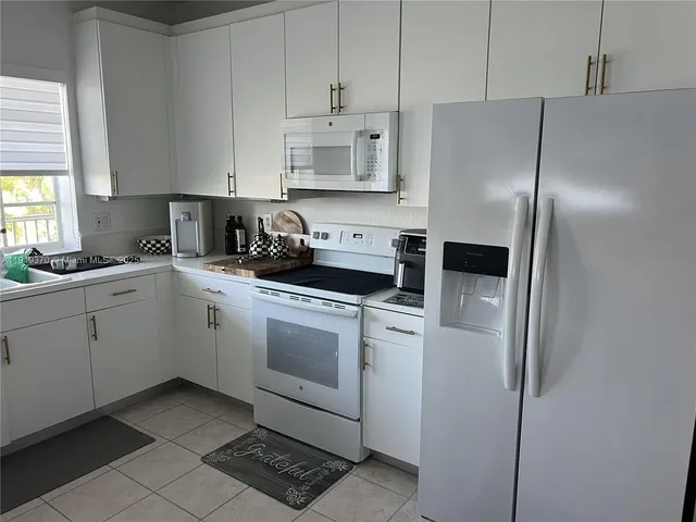 a kitchen with cabinets stainless steel appliances and a sink