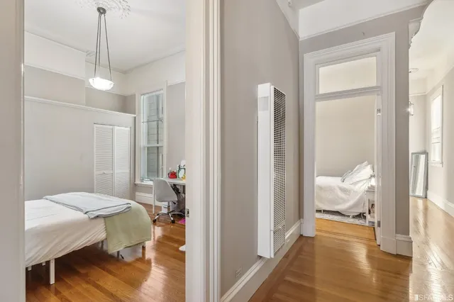 a bedroom with a bed and a flat tv screen on a dresser