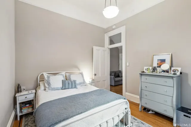 a view of a hallway with wooden floor and a cabinet