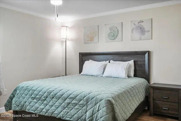 a bedroom with a bed chandelier and a window