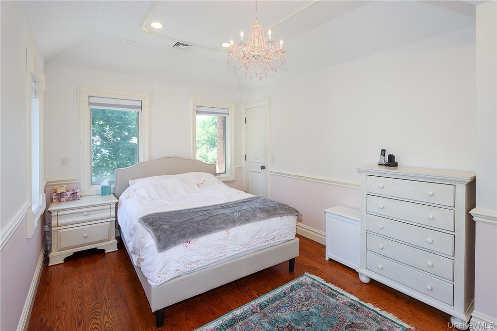 24 Steamboat Road Great Neck, NY 11024 - Photo 21 of 28 Bedroom featuring recessed lighting, wood finished floors, a chandelier, and vaulted ceiling
