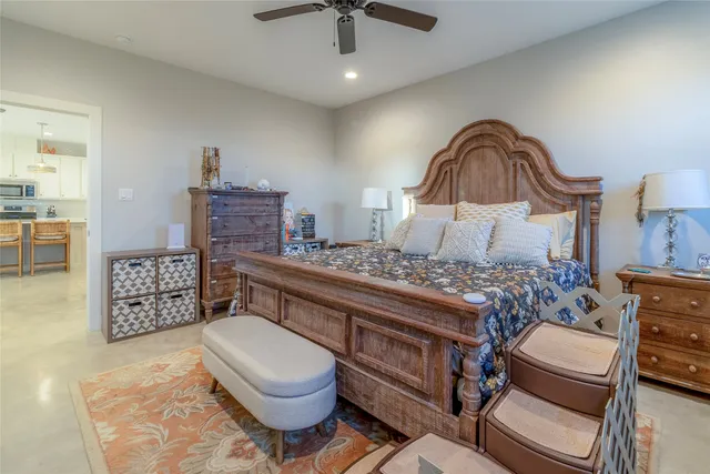 a bedroom with a bed a dresser and potted plant