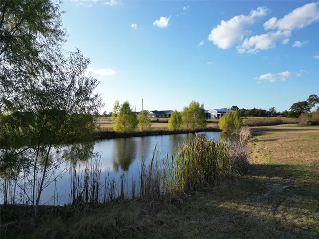 a large white kitchen with a large island oven a stove a sink a dining table and chairs