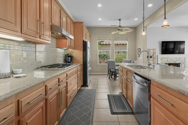 a large kitchen with stainless steel appliances granite countertop a stove a sink and a microwave