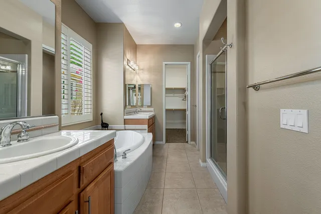 a spacious bathroom with a shower sink and mirror