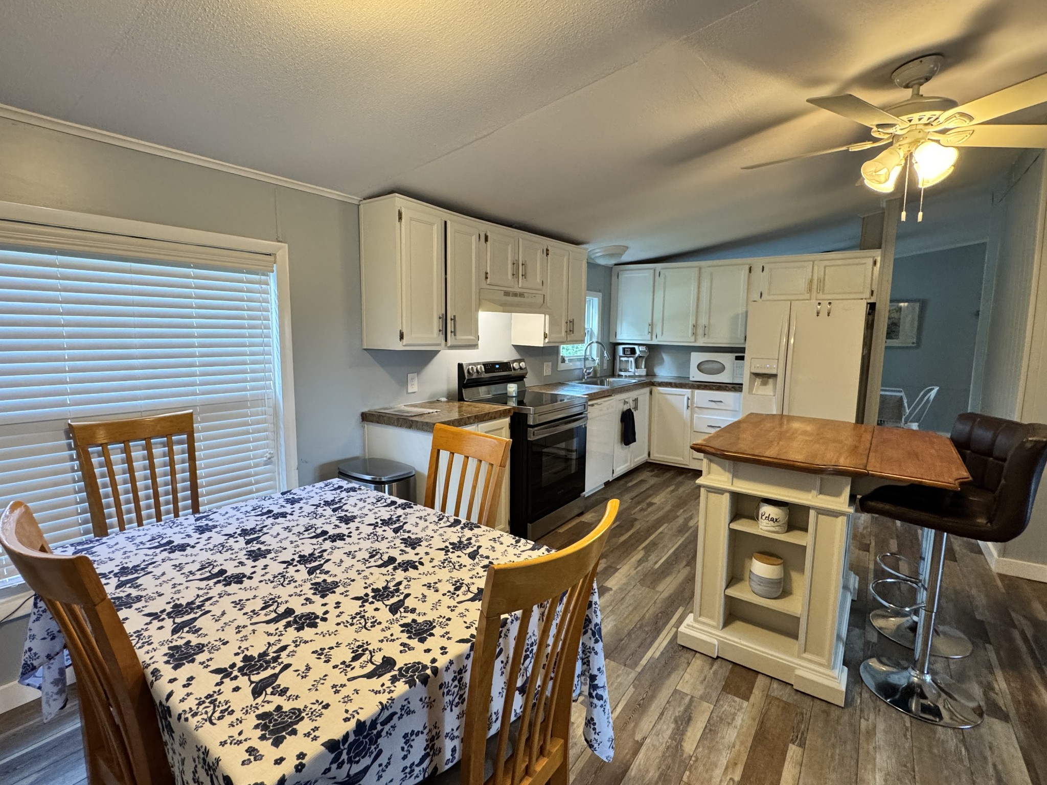 59 Riverview Lane Waverly, TN 37185 - Photo 7 of 28 a kitchen with kitchen island a stove a sink a refrigerator dining table and chairs