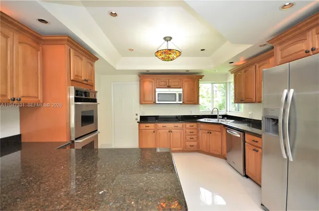 a kitchen with stainless steel appliances granite countertop a refrigerator and a sink