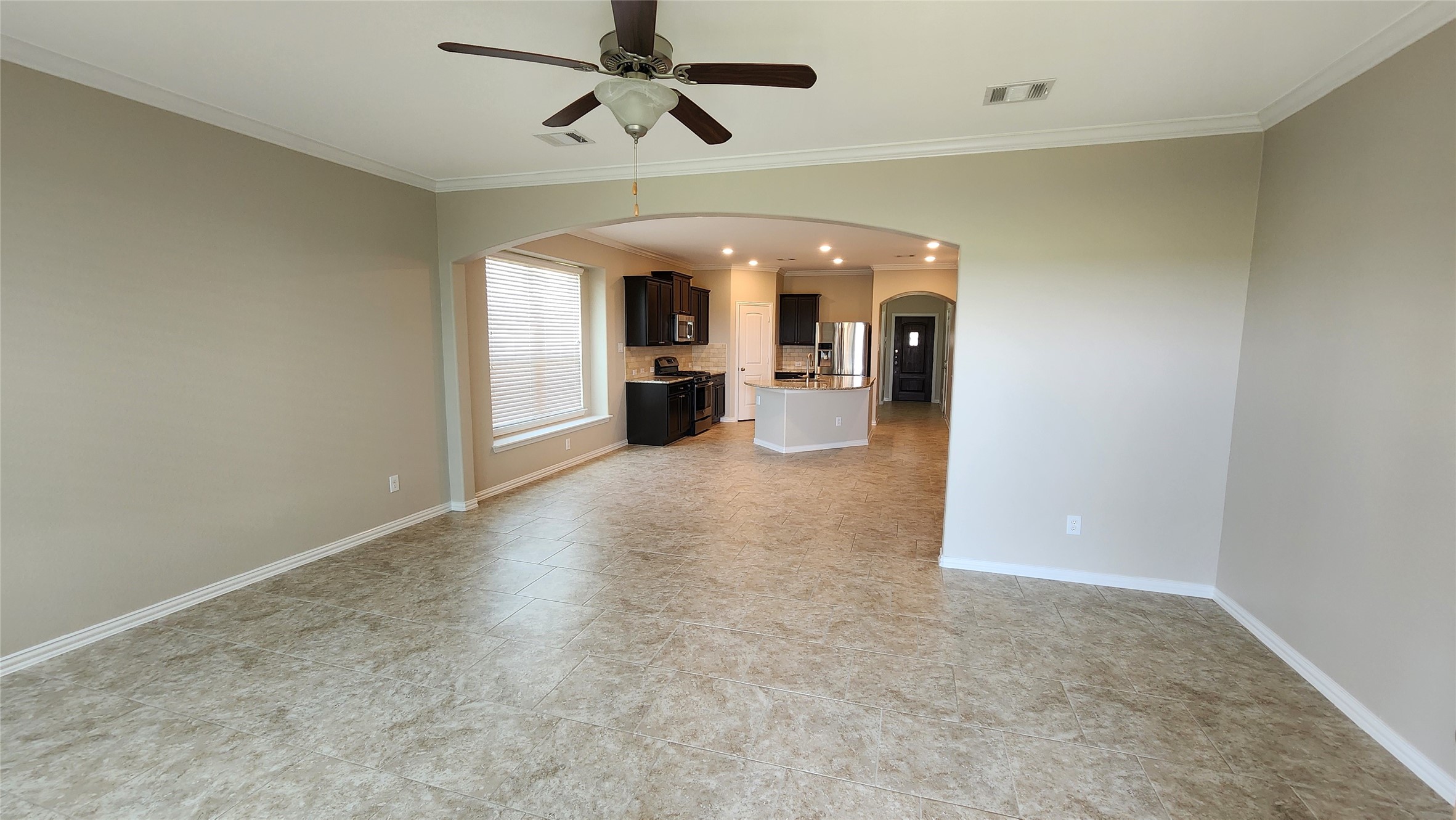 18428 Blush Rose Road Pflugerville, TX 78660 - Photo 16 of 32 Family room with crown molding. The tile is stylish and looks as close to new as you will find. This home looks more like a home built in 2022.