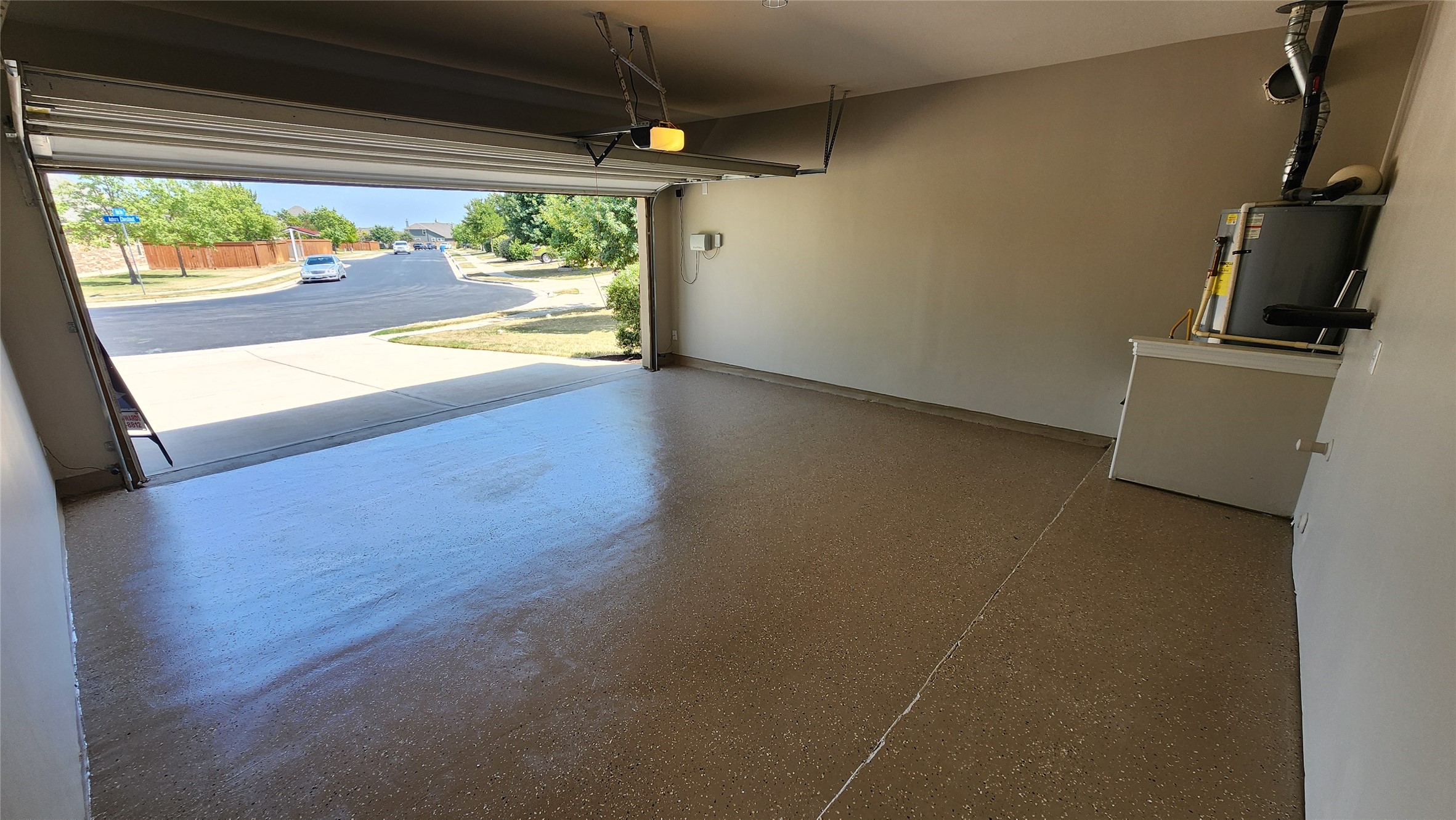 18428 Blush Rose Road Pflugerville, TX 78660 - Photo 25 of 32 Notice the sprinkler system control on the wall. The water heater is gas. The floor appears dark in this photo but it is actually a light color. See the other photos. There is a garage door opener and a keypad at the garage door exterior.