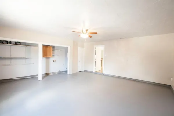 an empty room with a ceiling fan and window