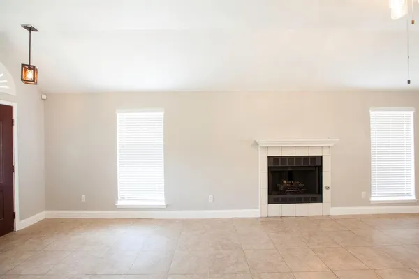 an empty room with a fireplace and window