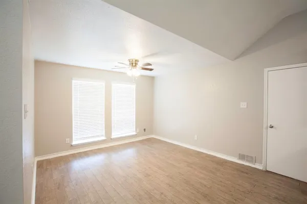 a view of an empty room with wooden floor
