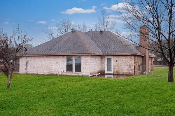 a front view of a house with a garden and trees