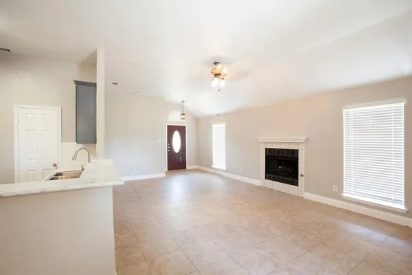 a view of an empty room with a fireplace and a window