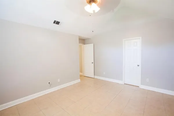 an empty room with a chandelier fan