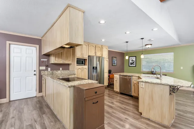 a kitchen with stainless steel appliances granite countertop a sink stove and refrigerator