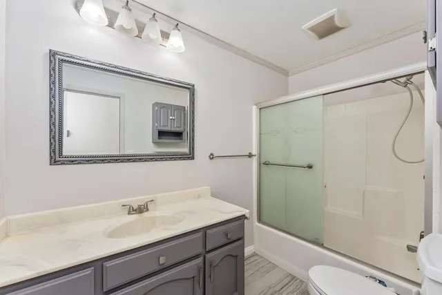 a bathroom with a granite countertop sink toilet a mirror and shower
