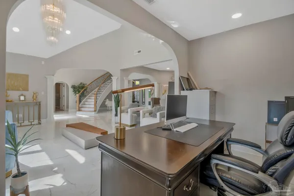 a living room with furniture a chandelier and a dining table