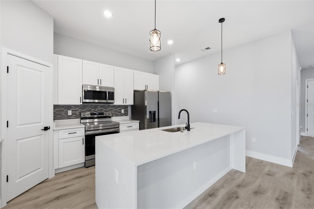 13975 Southwest 27 Ct Road Ocala, FL 34473 - Photo 12 of 35 a kitchen with stainless steel appliances a stove a sink and a refrigerator