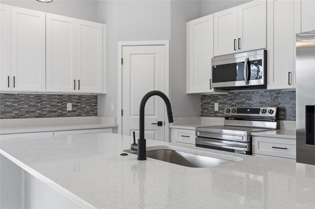 13975 Southwest 27 Ct Road Ocala, FL 34473 - Photo 14 of 35 a kitchen with stainless steel appliances granite countertop a stove and a white cabinets