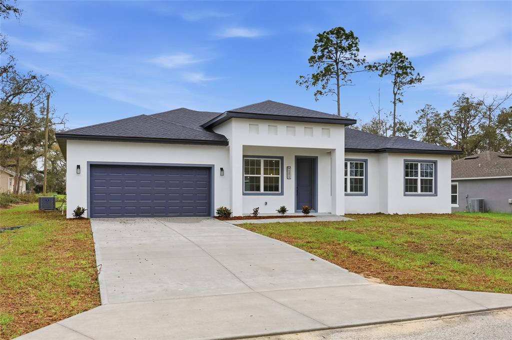 13975 Southwest 27 Ct Road Ocala, FL 34473 - Photo 2 of 35 a front view of a house with a yard and garage