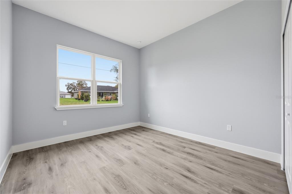 13975 Southwest 27 Ct Road Ocala, FL 34473 - Photo 22 of 35 an empty room with wooden floor and windows