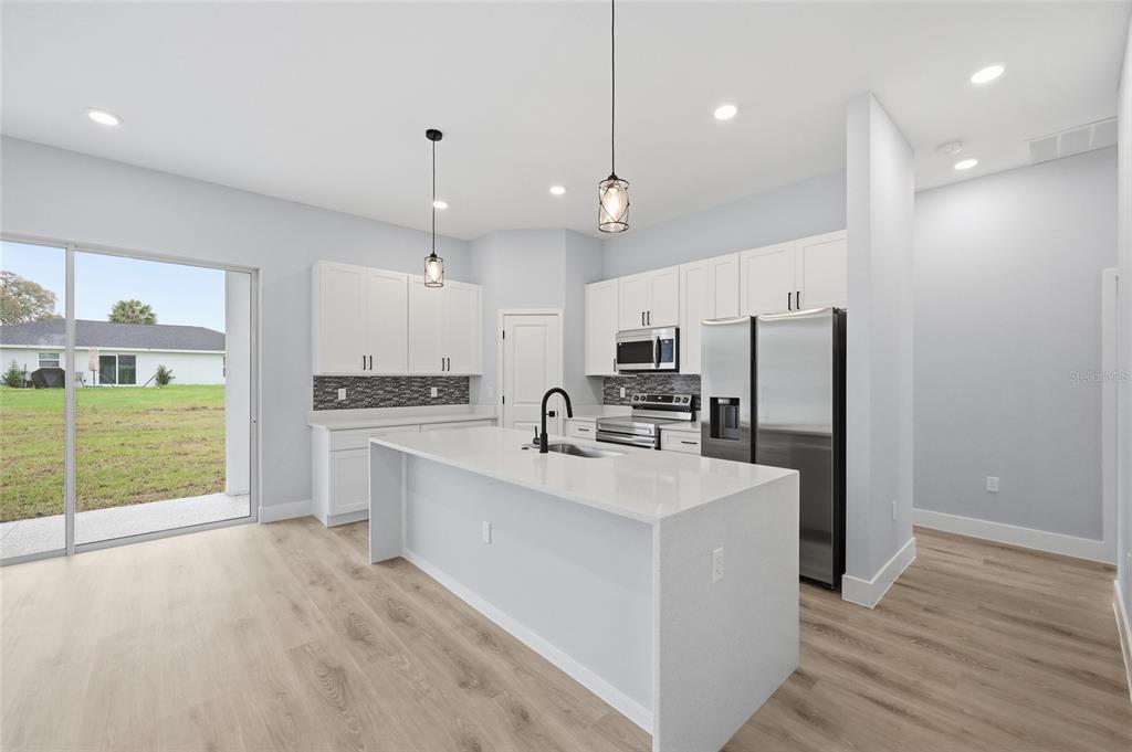 13975 Southwest 27 Ct Road Ocala, FL 34473 - Photo 10 of 35 a large kitchen with kitchen island a large counter top stainless steel appliances and cabinets