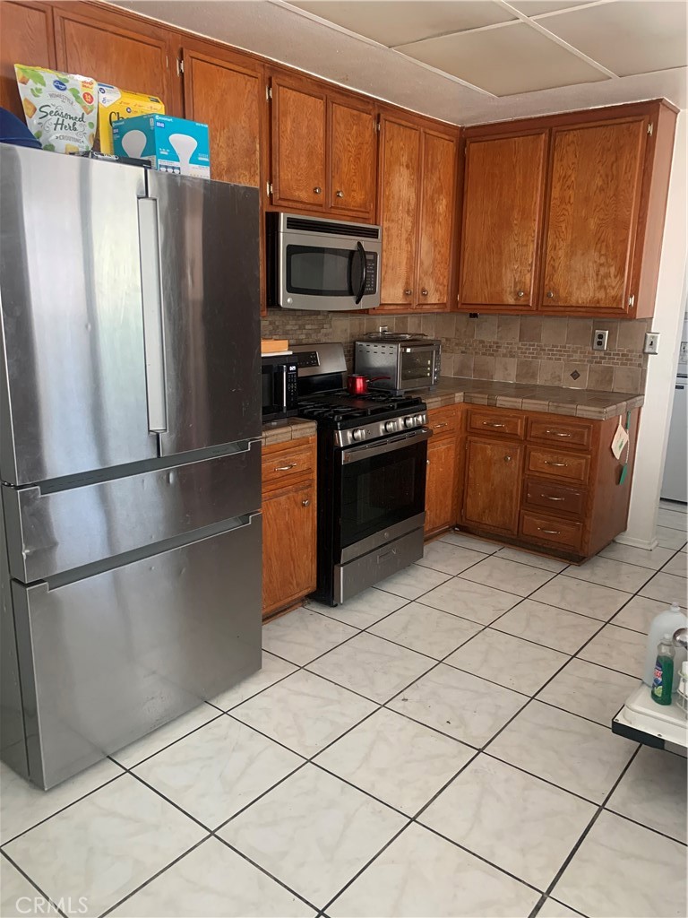 1144 North Glenwood Avenue Rialto, CA 92376 - Photo 11 of 35 a kitchen with stainless steel appliances granite countertop a refrigerator stove and microwave