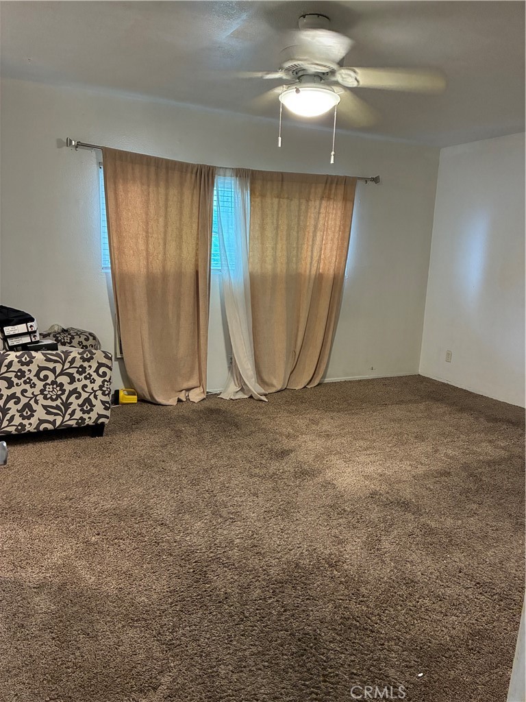 1144 North Glenwood Avenue Rialto, CA 92376 - Photo 28 of 35 an empty room with a window and ceiling fan
