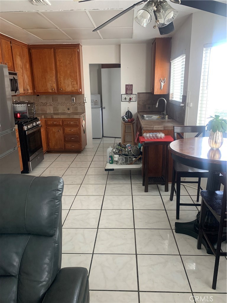 1144 North Glenwood Avenue Rialto, CA 92376 - Photo 10 of 35 a living room with stainless steel appliances kitchen island granite countertop furniture and a view of kitchen