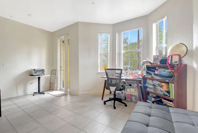 a view of a workspace with furniture and a window