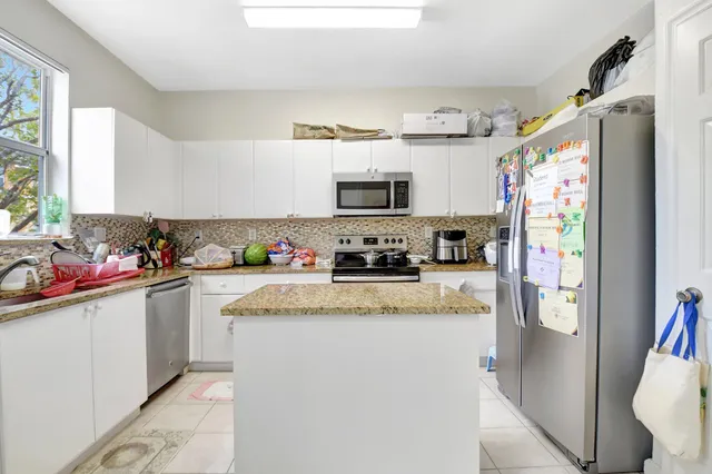 a kitchen with stainless steel appliances granite countertop a refrigerator and a sink