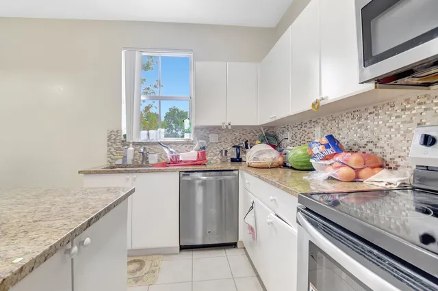 a kitchen with stainless steel appliances granite countertop a sink dishwasher and cabinets with wooden floor