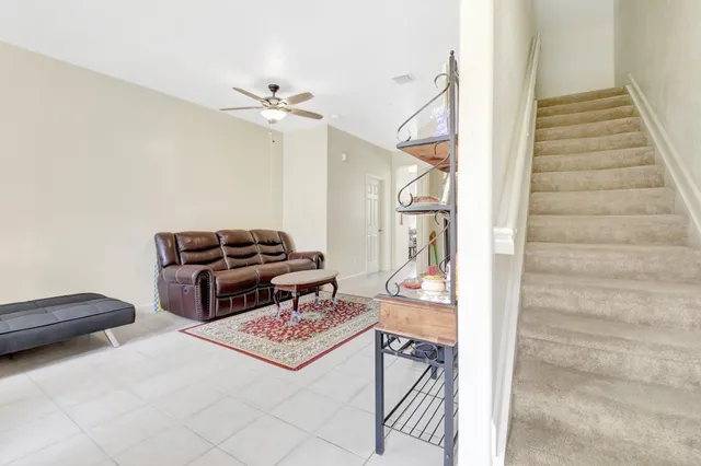 a living room with furniture and a ceiling fan