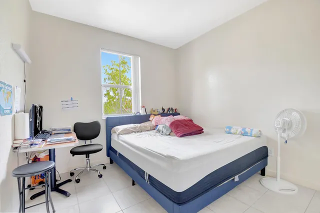 a bedroom with a bed and a white cabinet