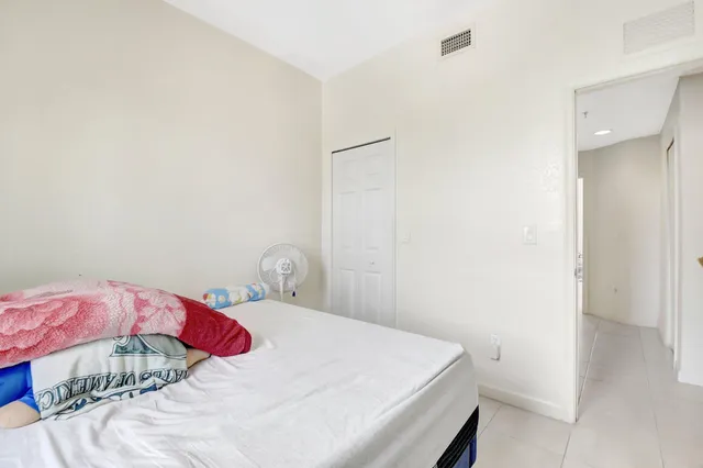 a bedroom with bed and a mirror