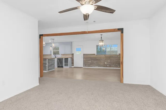 a backyard of a house with large trees and brick wall