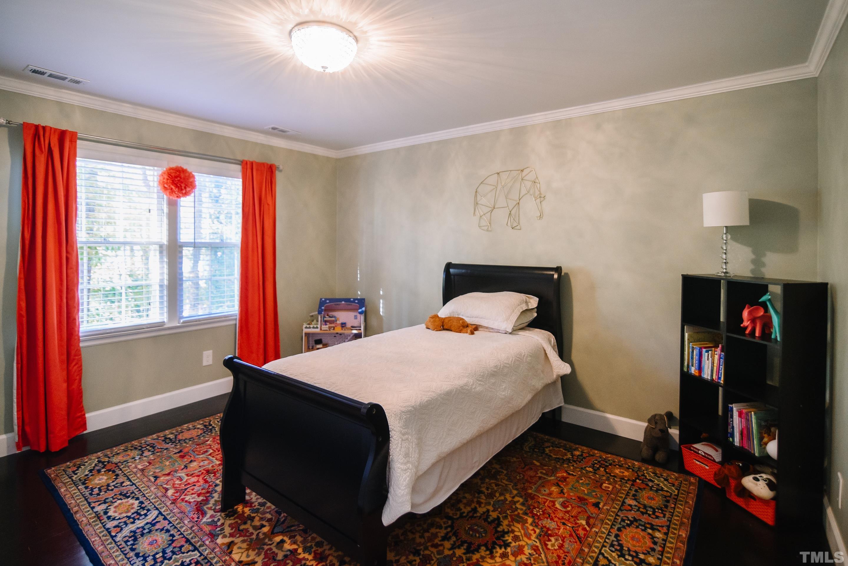 1501 Windbur Place Raleigh, NC 27609 - Photo 14 of 16 a bed sitting in a bedroom next to a window