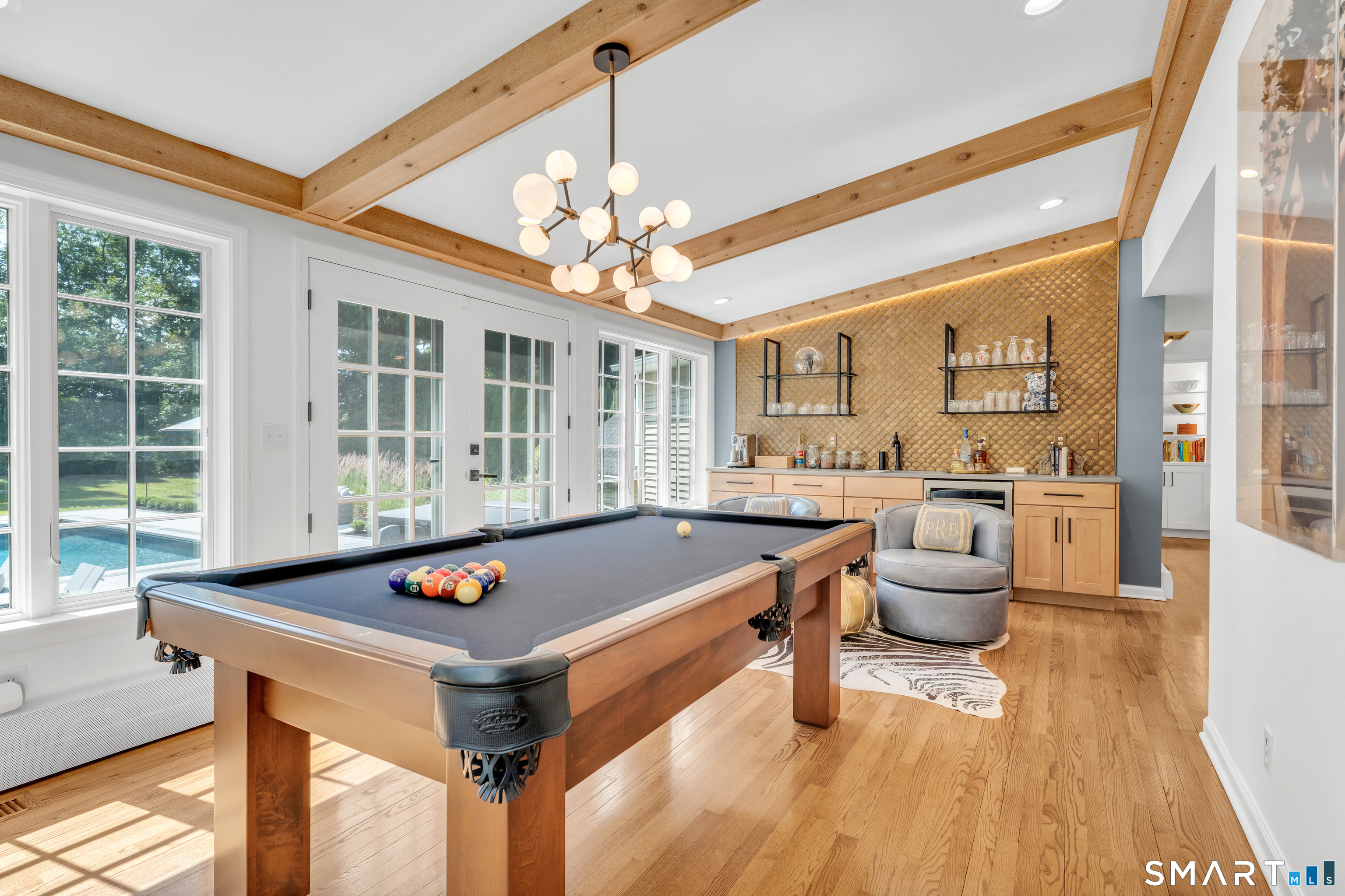 33 River Edge Farms Road Madison, CT 06443 - Photo 10 of 40 Vaulted ceilings, custom wood beams, French doors, and a sophisticated wet bar create an unforgettable setting for entertaining. Currently enjoyed as a billiards room, this flexible space easily adapts to your lifestyle.