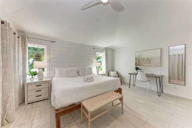 a bedroom with a bed a chandelier and a couch