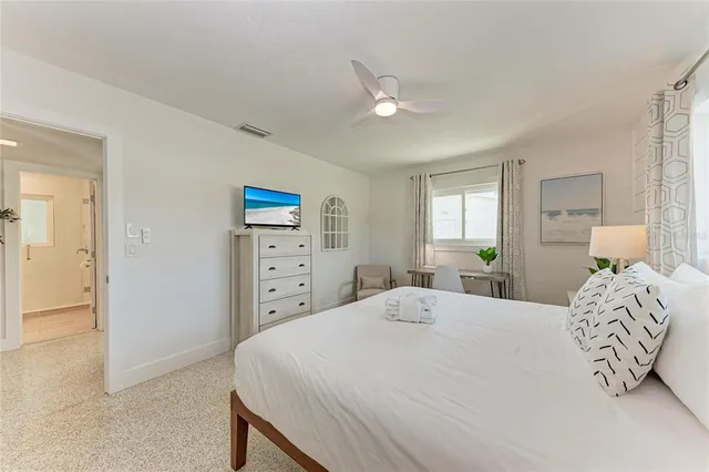 a bedroom with a bed and a potted plant