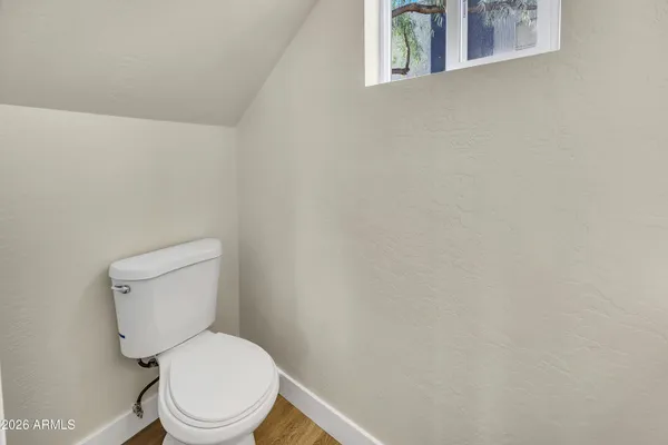 a white toilet sitting next to a white cabinet