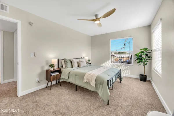 a spacious bedroom with a bed and a potted plant