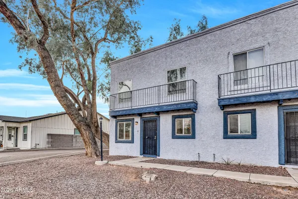 a front view of a house with a tree