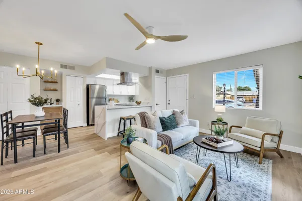 a living room with furniture kitchen view and a chandelier