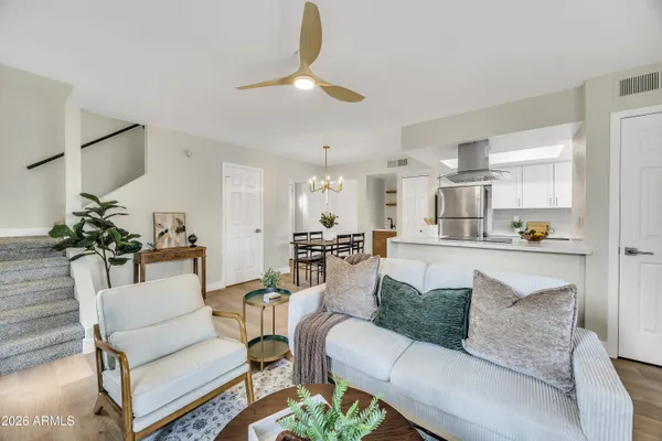 a living room with furniture and a dining table with kitchen view