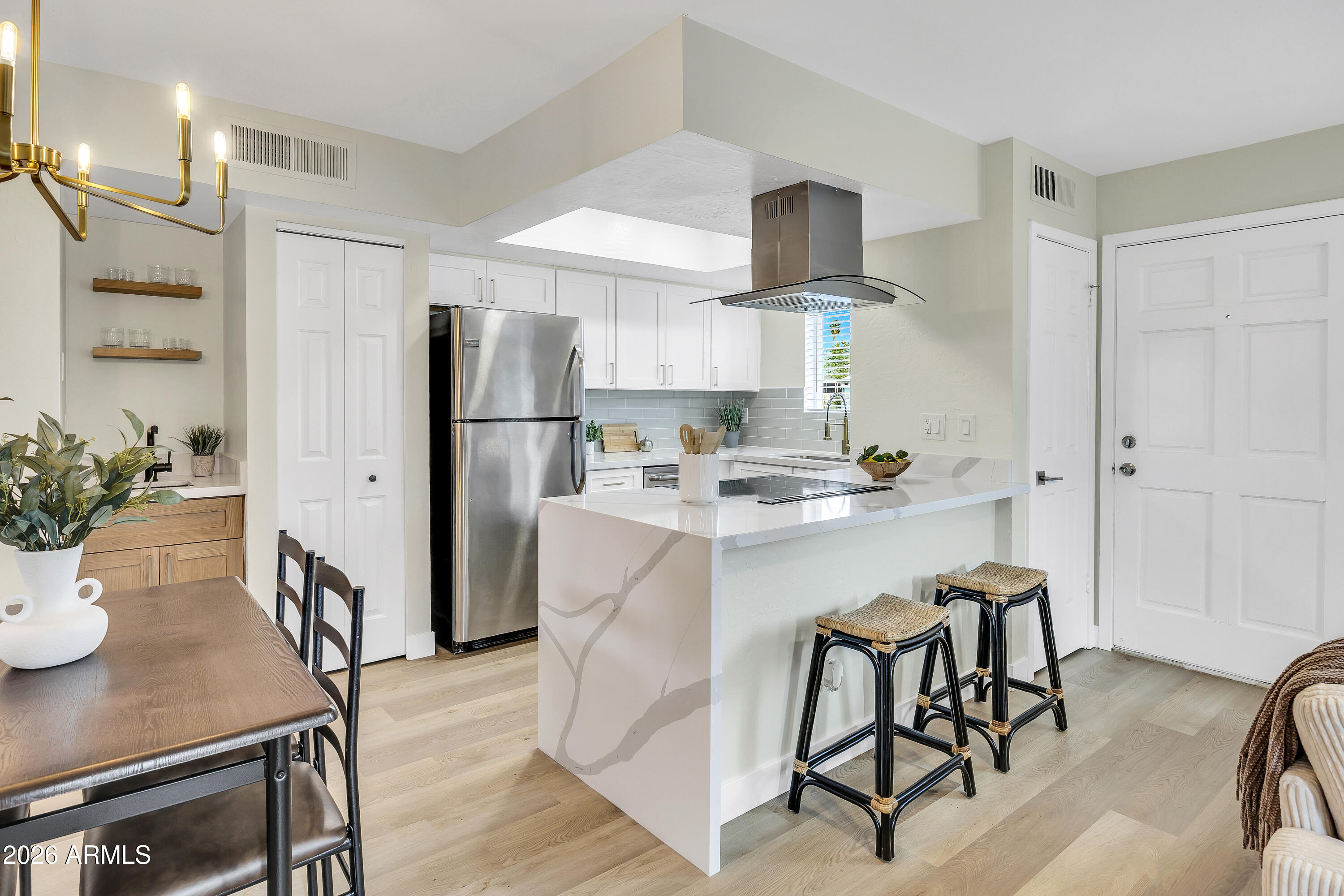 4142 North 11th Street, Unit 4 Phoenix, AZ 85014 - Photo 8 of 25 a kitchen with stainless steel appliances a refrigerator a stove a sink and chairs