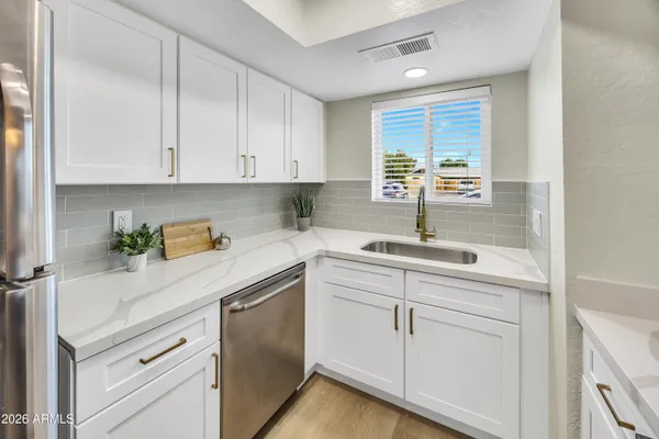a kitchen with white cabinets and white appliances